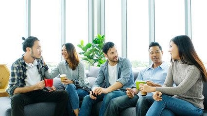 Group of happy creative team talking while taking coffee break at office