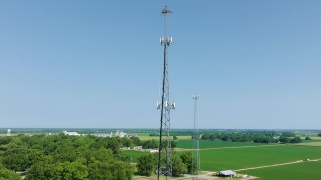 Drone orbit of two cell towers in a rural area with parallax.