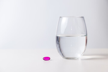 a pill with a glass of water, pandemic, health and wellness concept