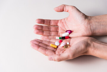 two hands with a handful of colored pills, pandemic, health and wellness concept