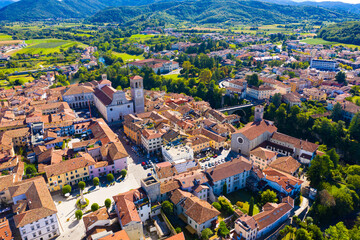 Fototapeta na wymiar Aerial view of Cividale del Friuli cityscape on banks of Natisone river overlooking Catholic cathedral and ancient bridge Ponte del Diavolo, Italy..