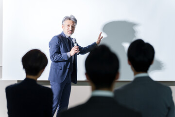 セミナーでプレゼンを行うミドルビジネスマン