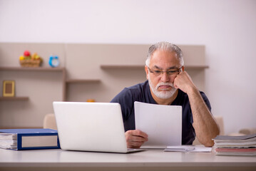 Old male employee working from home during pandemic