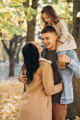 Fototapeta premium Happy young family spending time together in autumn park