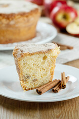 Close up piece of Sponge cake or chiffon cake with apples so soft and delicious sliced ​​with ingredients: cinnamon, eggs, flour, apples on wooden table. Home bakery concept for background.