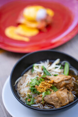 rice noodles in black soup serve with chicken