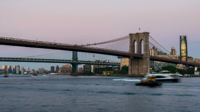 Late Evening Time Lapse Of the Brooklynn Bridge With Boats on the Water