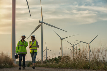couple walking in the countryside.person with wind turbine in the field. engineer with turbine in the wind. engineer with turbine - obrazy, fototapety, plakaty