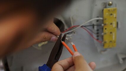 Electrical appliance, Electrician, The technician is repairing the electrical appliances in the house to return them to normal operation.