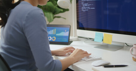 Asia young business woman sit busy at home office desk work code on desktop PC reskill upskill for job career remote self test IT deep tech ai design skill online html text for cyber security.