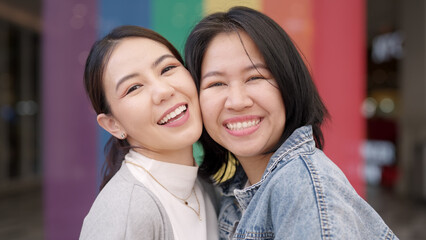 Young adult queer lover transgender asia two gay people fun happy enjoy relax look at camera. LGBT LGBTQIA beauty colorful flag color bisexual family festival hug love smile at city street town. © ChayTee