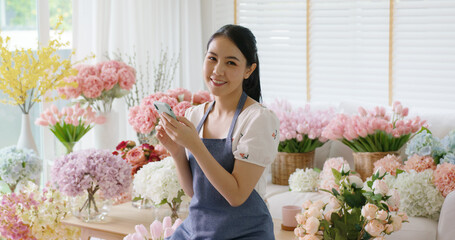 Asia people young woman SME owner happy smile look at camera enjoy open flower shop sale order web...