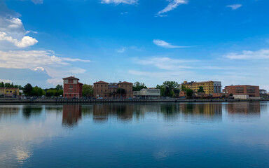 Fototapeta premium Beutiful buildings reflection on Ravenna's darsena on a morning sunny day . a dock is an enclosed area of water used for loading, unloading, building or repairing&nbsp;ships.&nbsp;Emilia-Romagna tourism