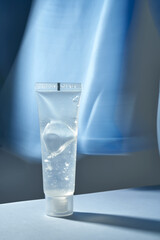 Transparent bottle of cosmetic gel on a blue background.