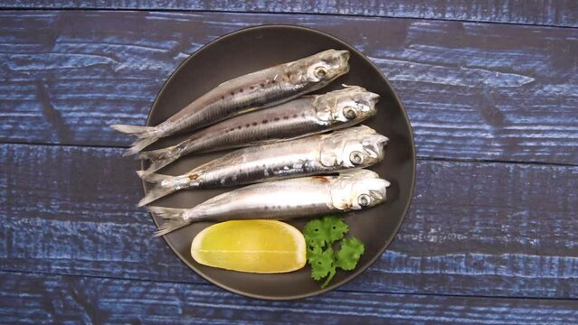 Rotating saltwater fish sardine on the table