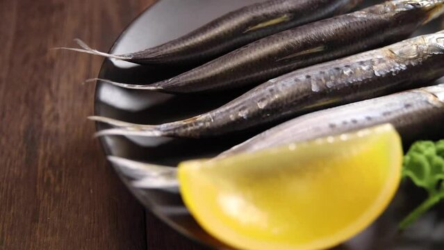 Rotating saltwater fish sardine on the table