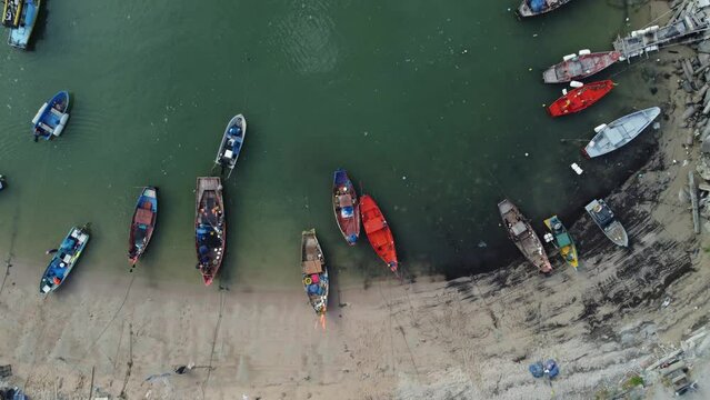 Small fishing boats are lined up behind the rocky shoreline, Aerial view, Eastern of Thailand