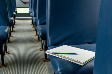 Empty School Bus Seats with notebook and pencil