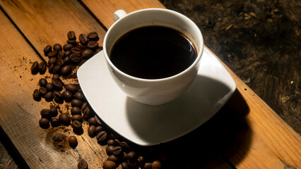 a cup of hot black coffee on a wooden board