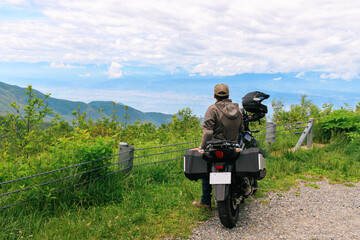 バイクで訪れた峠道で景色を眺める