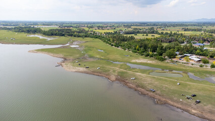 Aerial view from done over camping area inside Pasak Chonlasit dam between duble sugar palm tree with water bay and green area. Most of tourist all this area is "New Zealand Thailand".