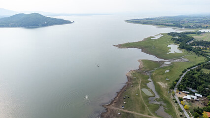Aerial view from done over camping area inside Pasak Chonlasit dam between duble sugar palm tree with water bay and green area. Most of tourist all this area is "New Zealand Thailand".