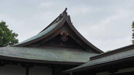 Naklejka premium Old traditional temple architecture of Japan, rustic “Gegyo” decor and the “Omune” on the top of the roof, cloudy sky year 2022 June 23rd at “Kiyomizu Kannon-do” Tokyo Japan