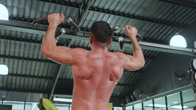 Strong Fitness trainer sportsman or athlete lift up body on bar in sport club.