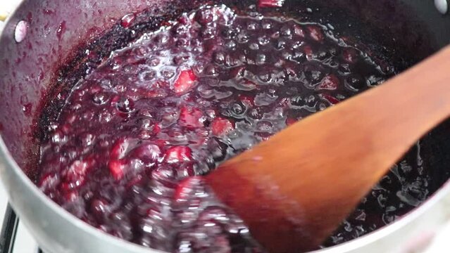 Making homemade jam : Boil the aronia, peach, sugar and lemon juice. Aronia is a superfood, also called chokeberry or king's berry.