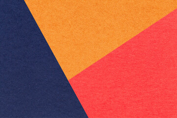 Fototapeta premium Texture of craft navy blue, orange and red shade color paper background, macro. Structure of vintage abstract cardboard