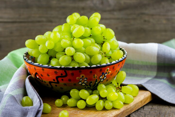 Green grapes in a bowl on a table with a towel