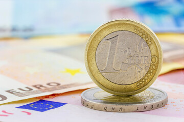 One euro coin on edge and euro banknote.