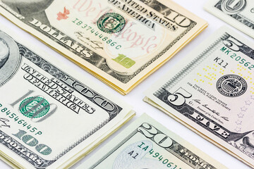 Stacks of dollar bills of various denominations
