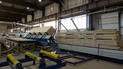 Woodworking production with computerized automatic equipment. The boards are moving along a...