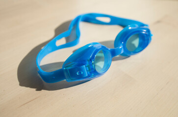 swimming goggles for children, blue, on a light background. Import supplies of accessories, glasses for athletes. Attribute for swimming in the pool