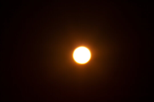 Bright blurred yellow spot. The sun on a black background