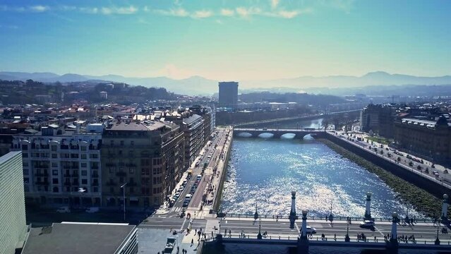 amazing lift up drone shot over Urumea river and the old town of San Sebasti&aacute;n we see the buildings with the Kursaal art gallery the wonders of the sea in background during a lovely sunny day