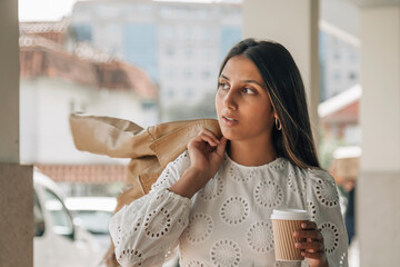 young latin american girl with coffee to go on the street