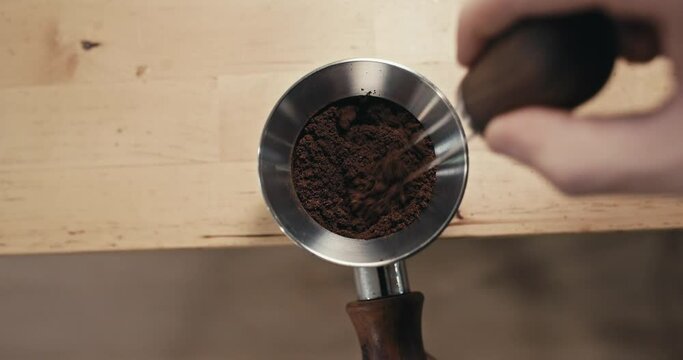 Barista Preparing Espresso Coffee Grinds with WDT Tool from Bottomless Portafilter, Closeup of Weiss Distribution Technique in Slow Motion 4K