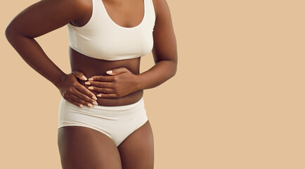 Fototapeta Crop of African American woman on yellow studio background suffer from appendicitis spasm. Pain in right lower stomach part. Unhealthy black female have acute ache in belly need hospitalization. obraz