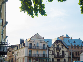 Naklejka premium Lutsk, Ukraine. Beautiful old buildings on the Drahomanov Street of Lutsk. Crowded street construction in summer evening.