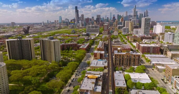 Sunny panorama of beautiful green districts of Chicago, Illinois. Gorgeous skyscrapers at the backdrop against blue cloudy sky.