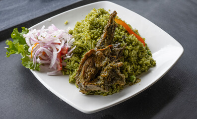 Peruvian food, rice with duck, accompanied by onion and lettuce.