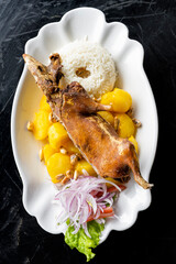 Peruvian food: Roasted guinea pig served with potatoes and rice, traditional in Peru, Ecuador and Bolivia. Top View