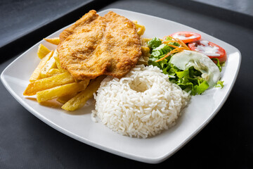 Milanese fried chicken cutlet with salad, French fries and rice