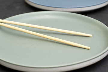 two plates and chopsticks on a black background