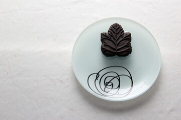 Delicious chocolate cookies filled with vanilla cream made with honey or maple syrup from Canadian trees, the traditional sweet of Canada in white plate on a white bakground