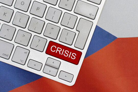 White computer keyboard with red button with word of crisis on Czech Republic flag background. Global economic, political and financial crisis. Economic crisis and economic recession in Czech Republic