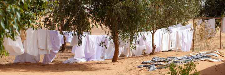 Ropa blanca tendida al aire libre sobre la arena