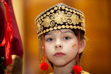 A little girl in the Uzbek national headdress.